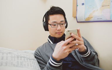 student on phone with headphones